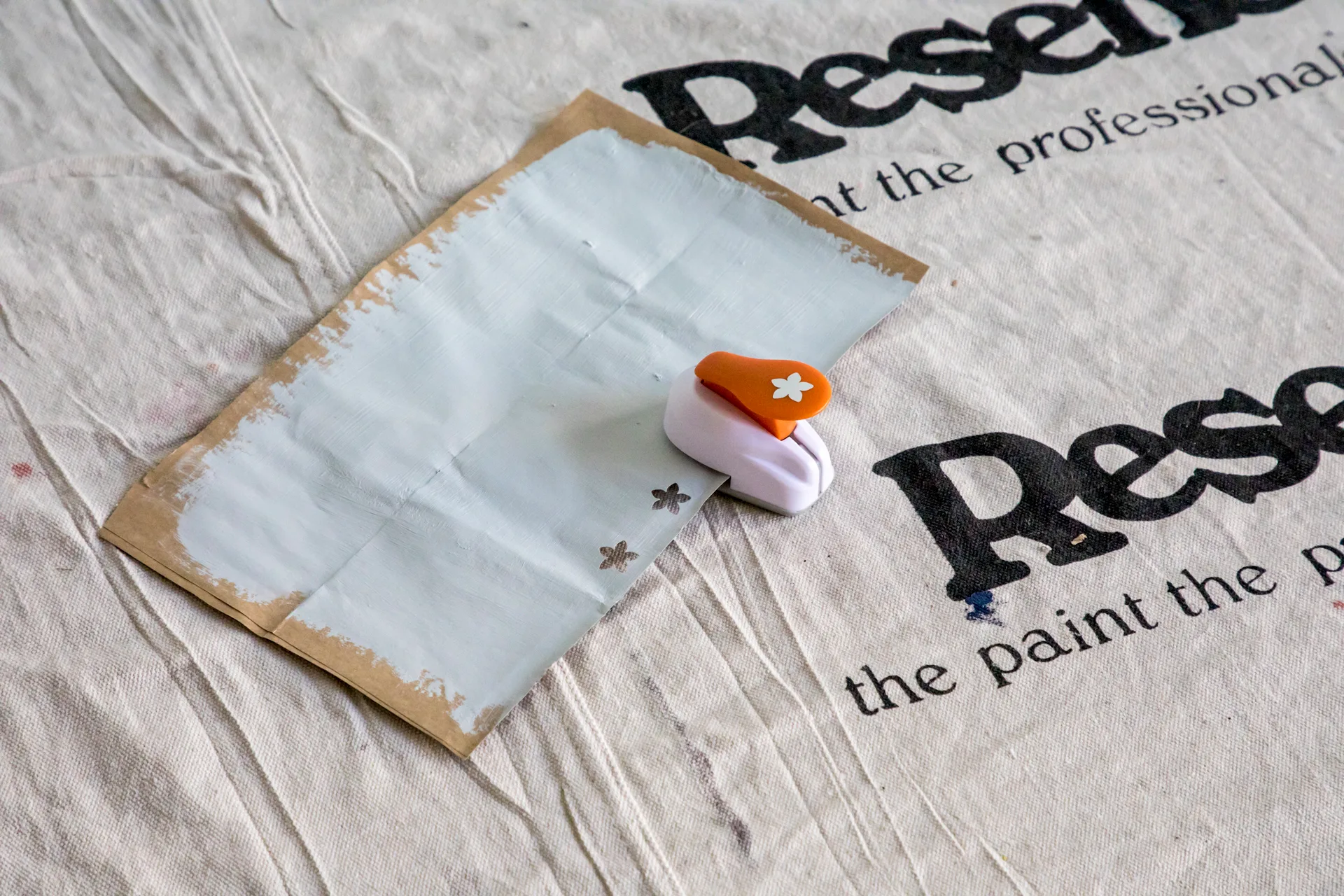 Hole punching shapes into painted paper bag