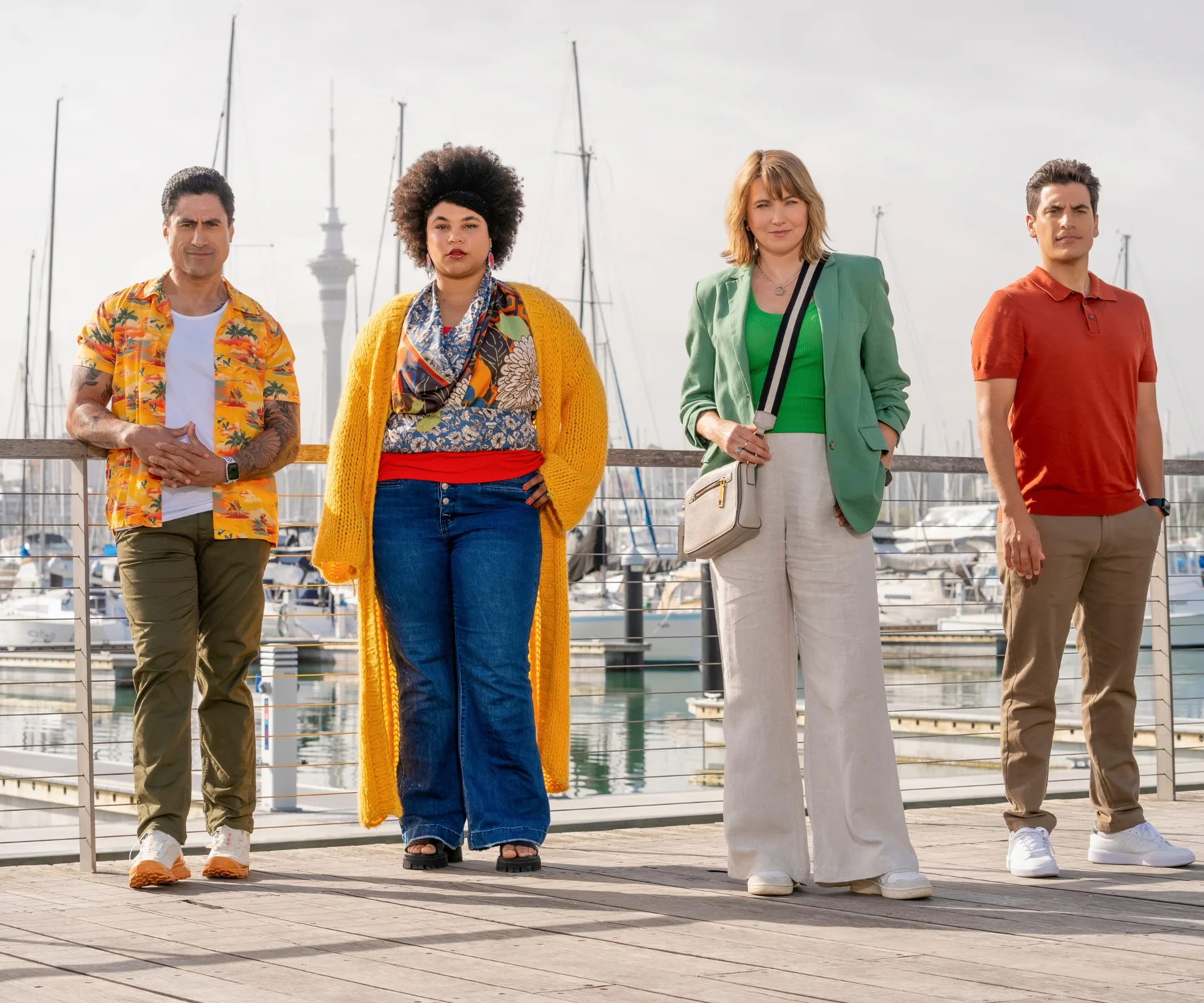 Lucy standing on a boardwalk with her My Life As Murder co-stars