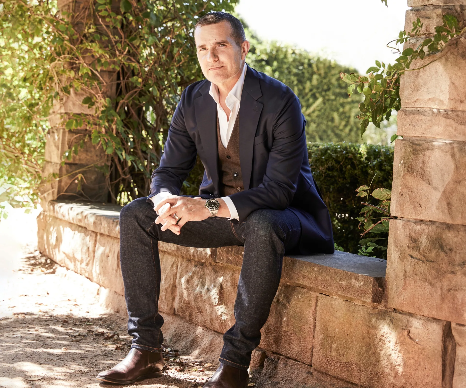 John Aiken sitting on a stone ledge