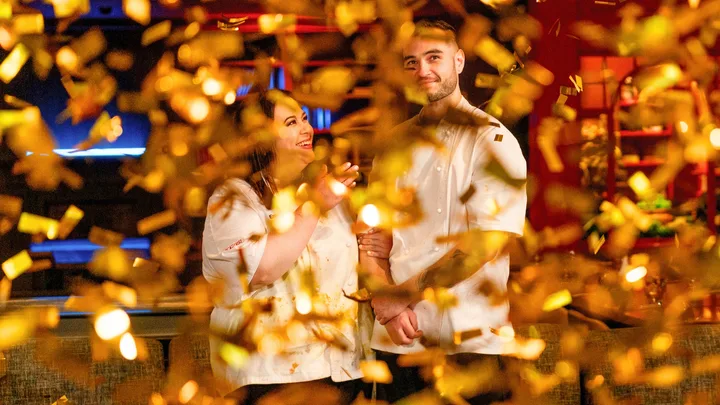 Two chefs smiling amid falling gold confetti.