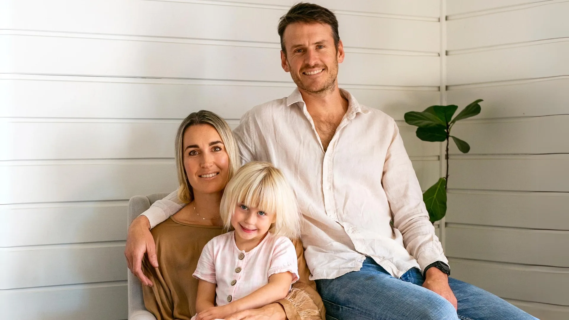 Gigi Lockwood sitting on mum, Charlotte's lap, with dad, Sam behind them