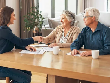 An elderly couple sitting at a table to discuss their retirement planning with an expert