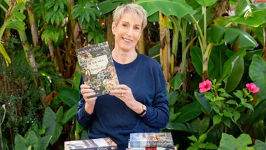 Deborah Challinor holding up her new history based book