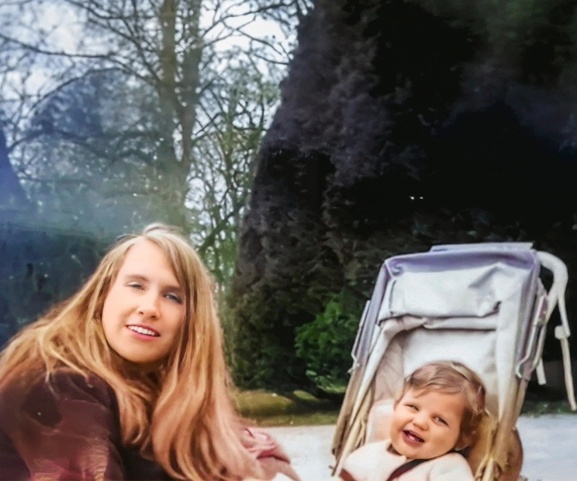 An old photo of Matt as a baby in a pram, with mother Rosemary crouched down in front of him