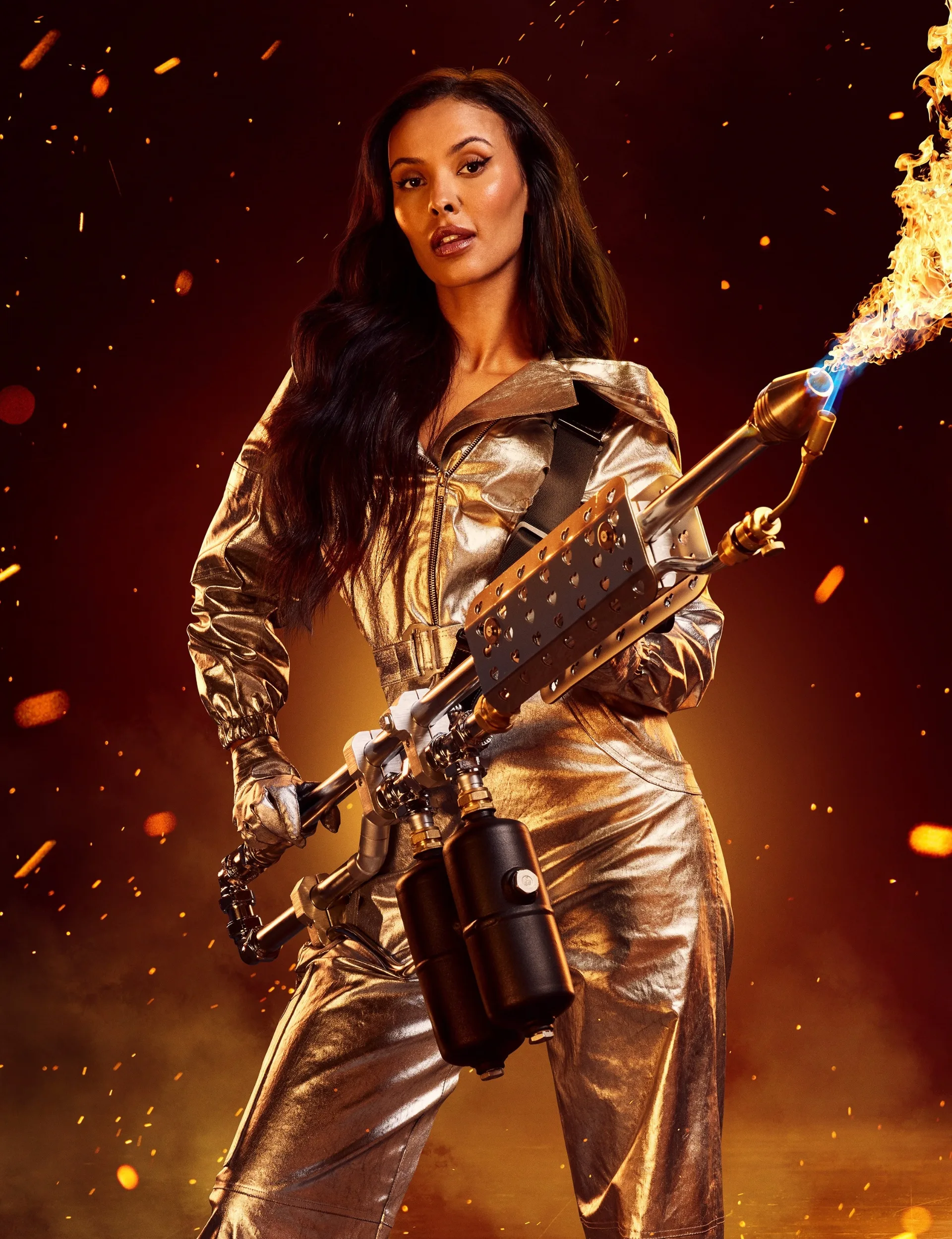 Love Island UK 2024 host Maya Jama wearing gold and holding a flame thrower