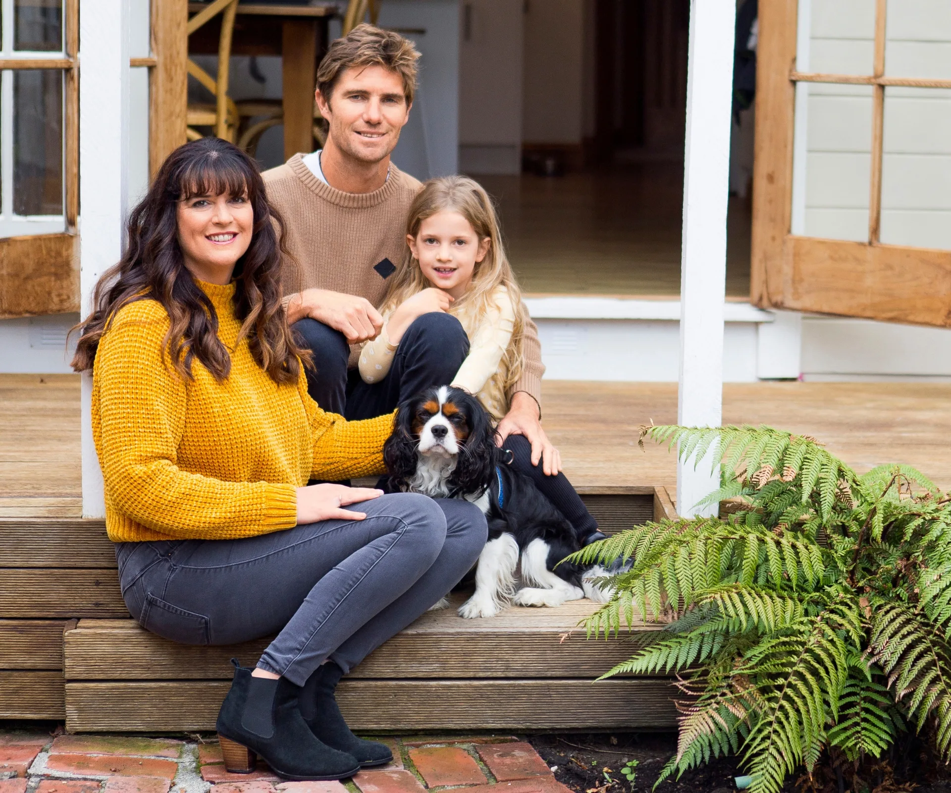 Vickie, Ruby and Ryan sitting on their porch steps