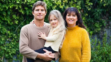 Vickie Hudson-Craig standing beside husband Ryan, who is holding their daughter Ruby