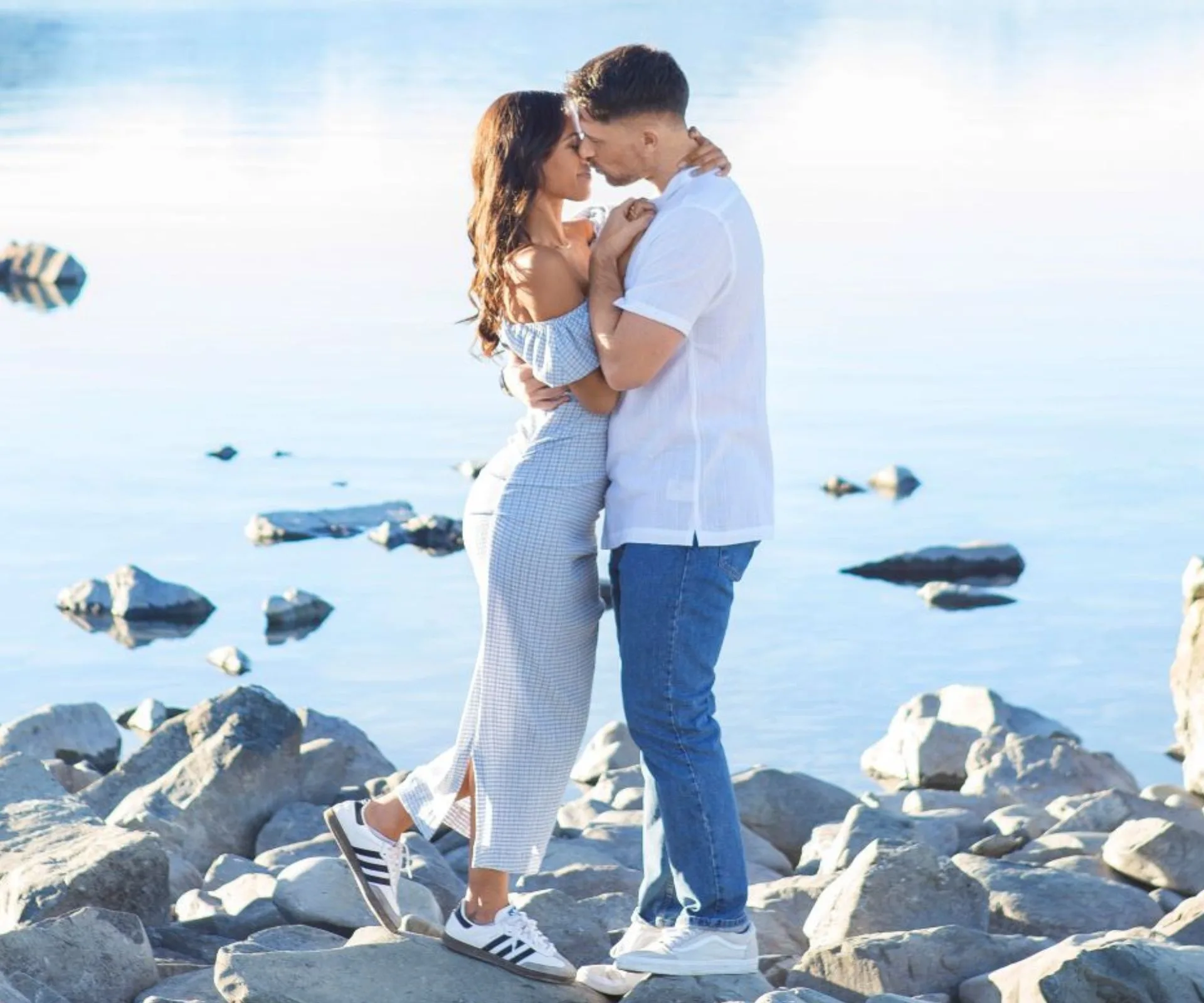 Lesina leaning into Tom about to kiss him on the rocks in front of the lake