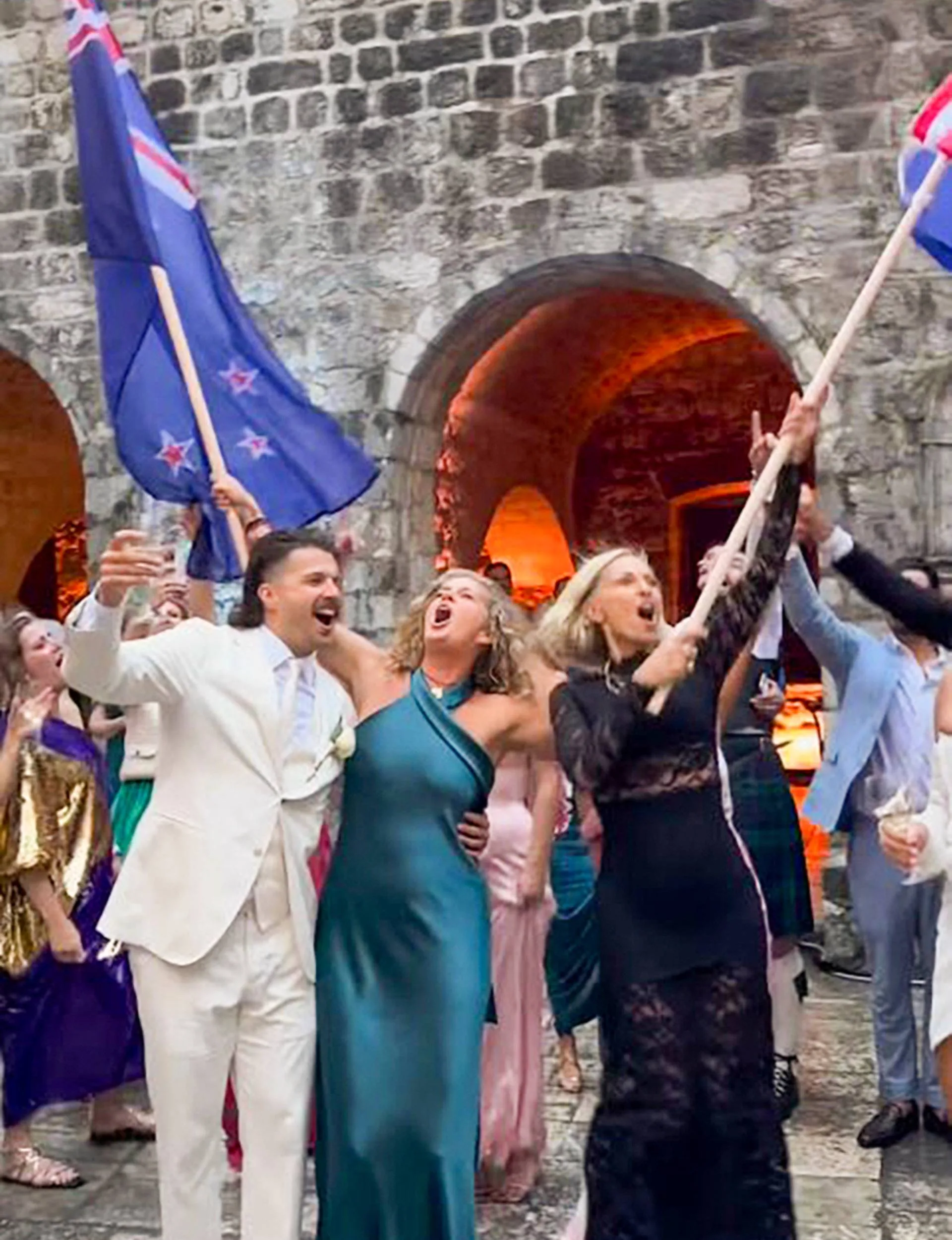 Rachel Hunter and the bride's mum Tina waving flags from their home countries with Liam