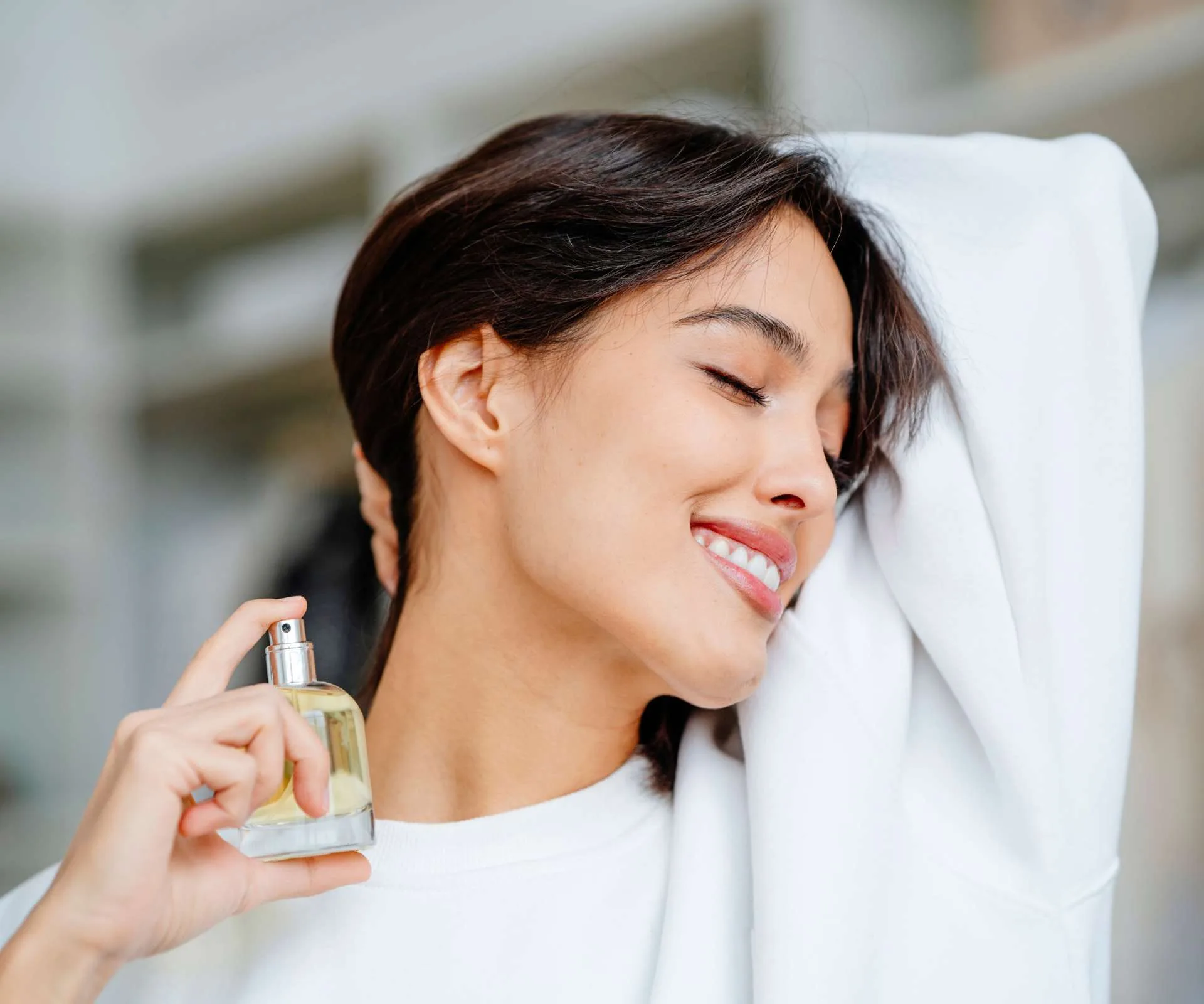 Model woman spraying perfume on her neck