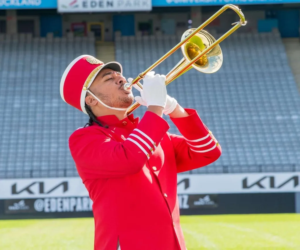 Haanz blowing his trombone in his red band costume