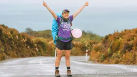 Kate celebrating with her arms in the air at the end of the walk