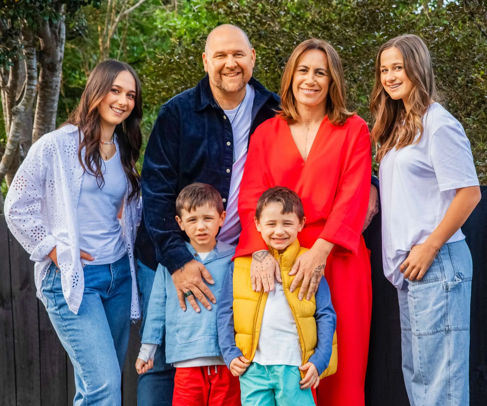 Jenny-May surrounded by her husband and their children in front of the back garden fence