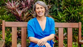 Jenny-May wearing Blue sitting on a wooden picnic bench