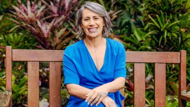 Jenny-May wearing Blue sitting on a wooden picnic bench