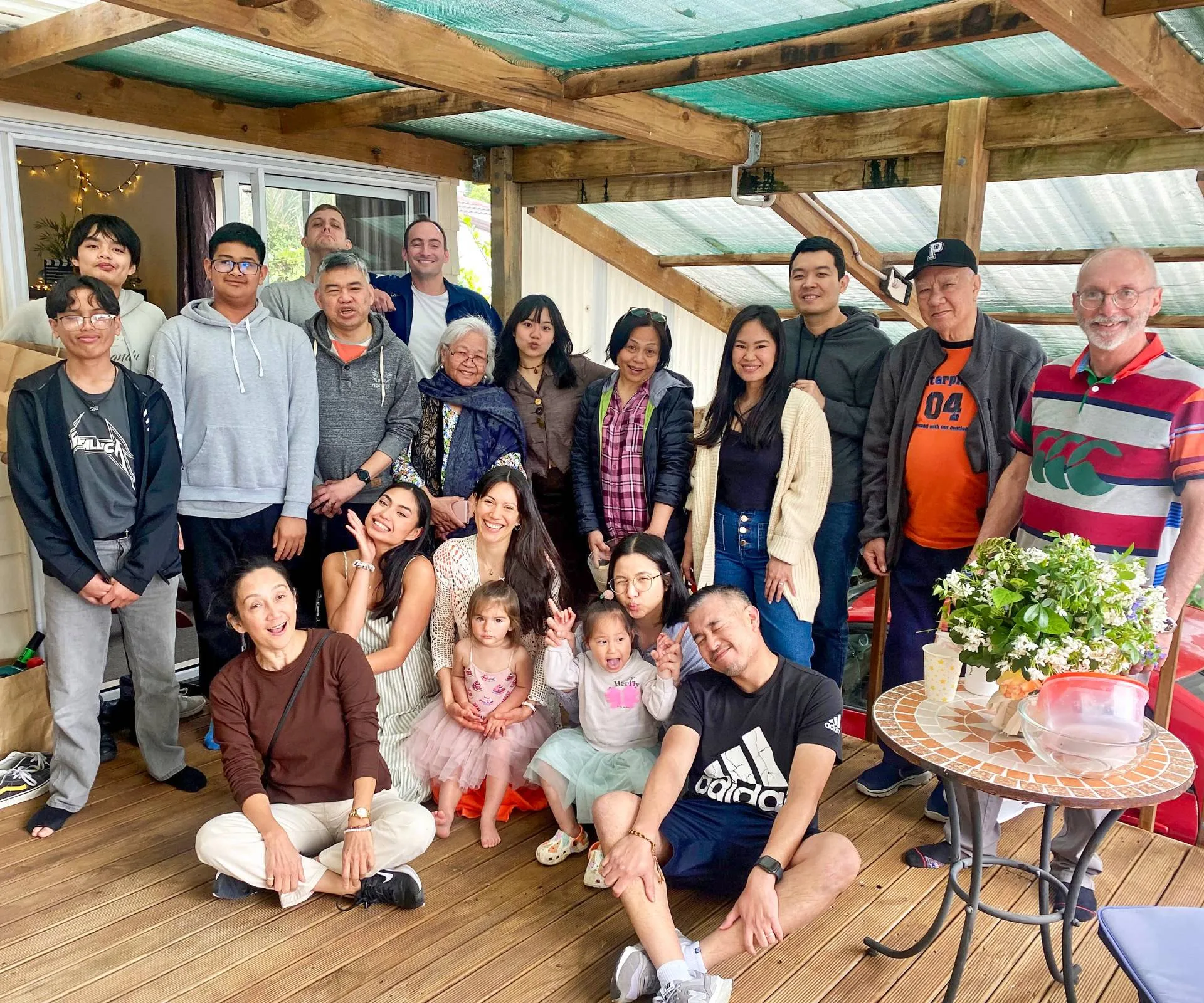 A group photo of Charisse with 20 other family members on the porch of a home