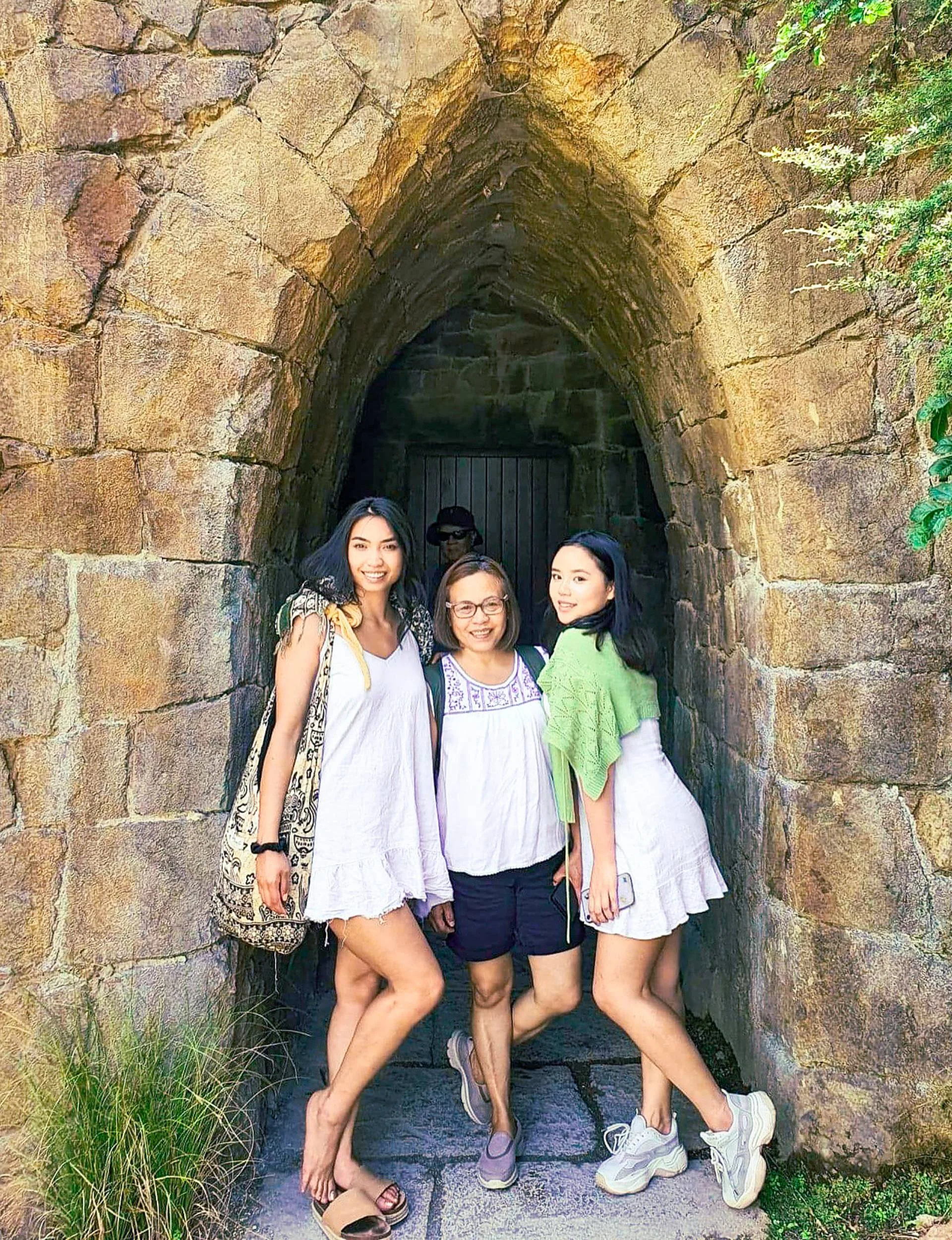 Charisse in a stone archway with her mum and sister