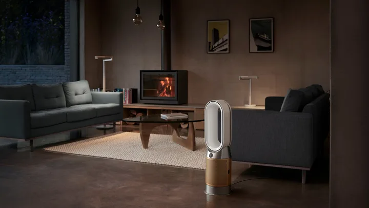 Modern living room with a fireplace, sofas, and a Dyson air purifier on the floor.