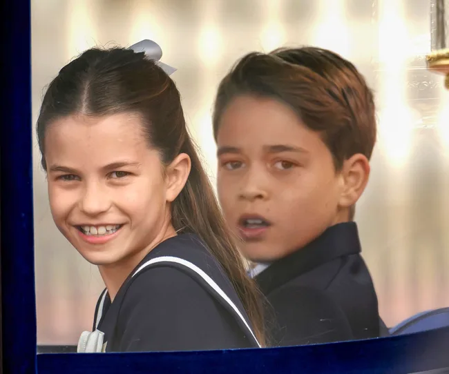 Prince Louis and Princess Charlotte smiling through a carriage window