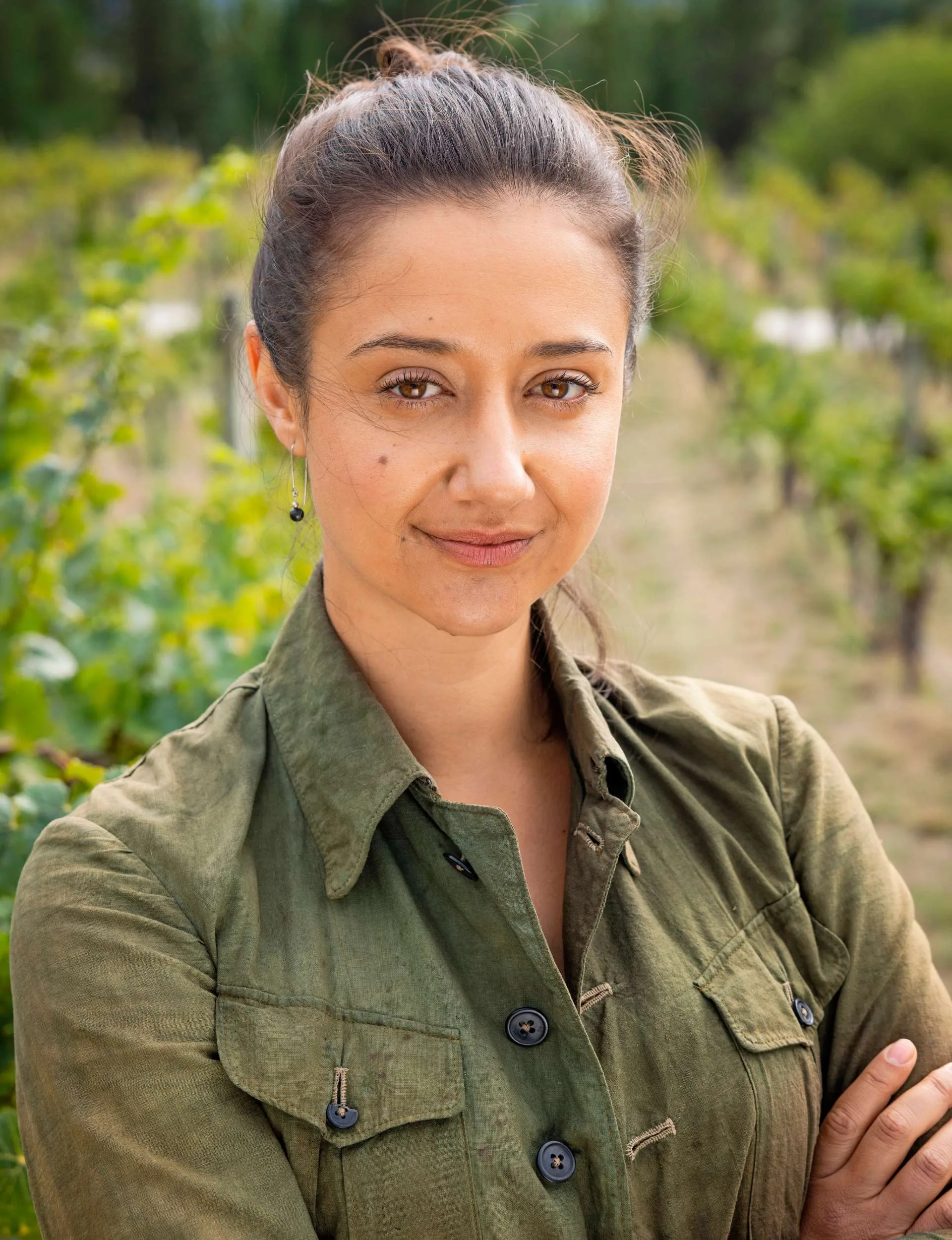 Trae Te Wiki standing in a vineyard with her arms crossed