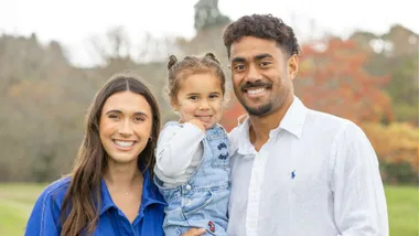 Emoni Narawa holding daughter Milla, standing with partner Danielle