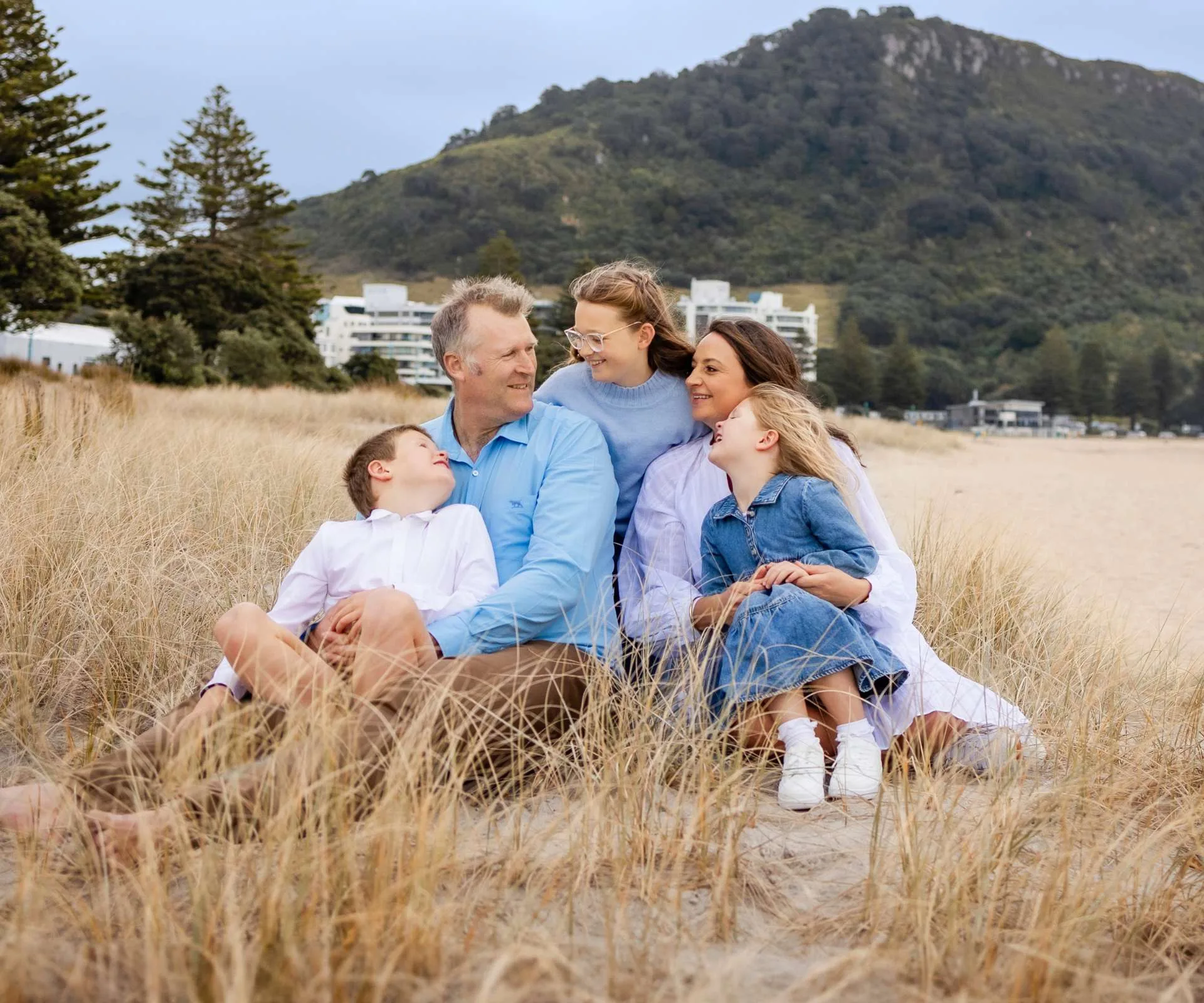 The Drysdale family sitting in tall grasses spending time together