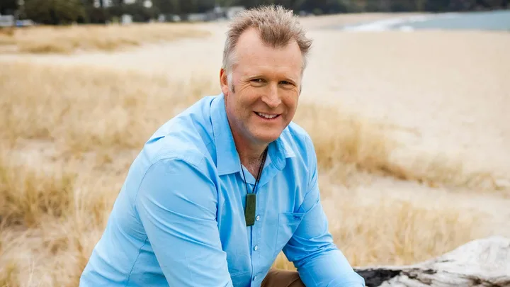 Mahe Drysdale sitting in some tall grasses
