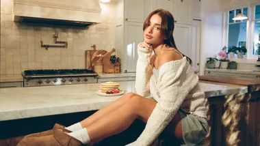 Woman sitting in loungewear in kitchen