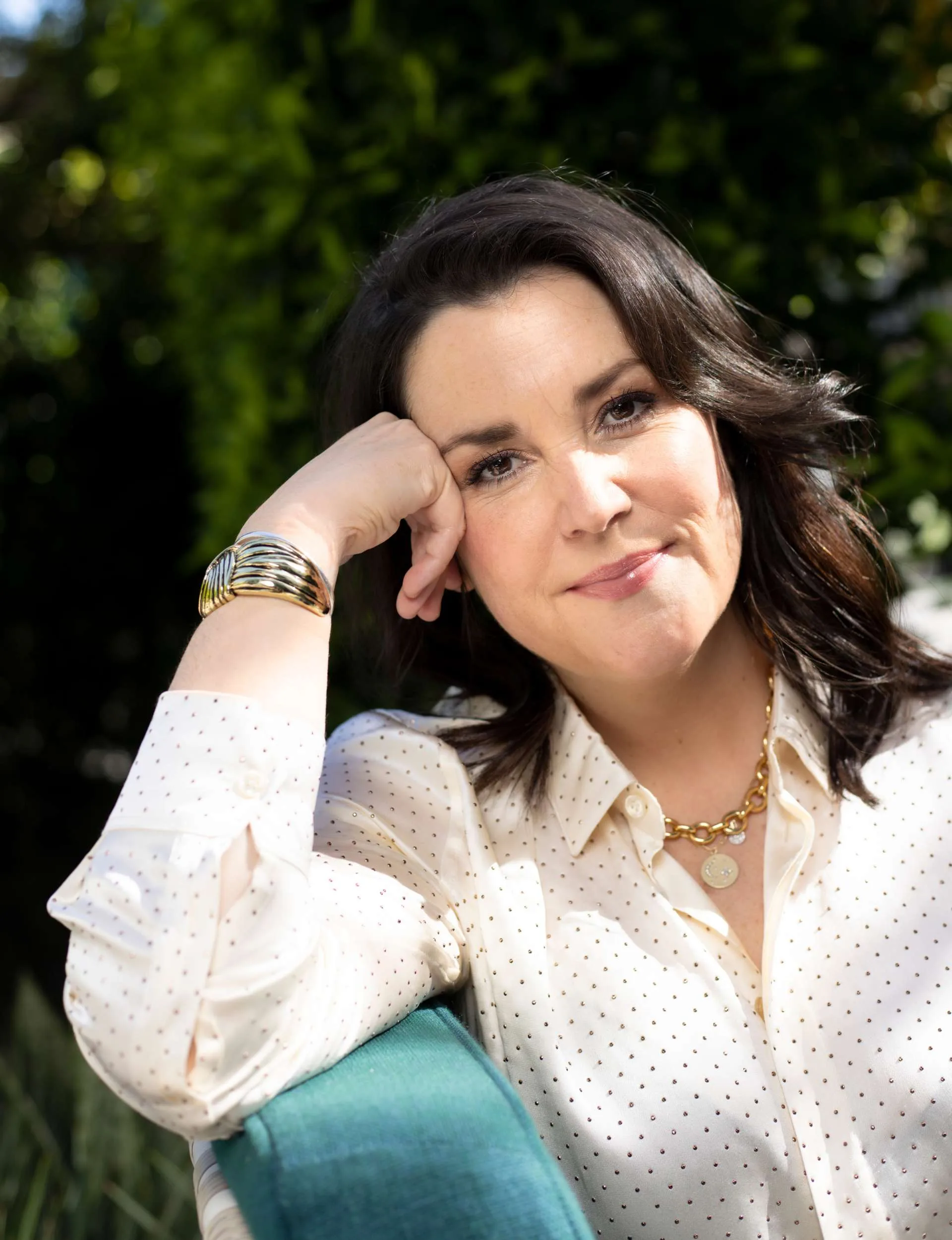 Melanie leaning on her knee looking at the camera