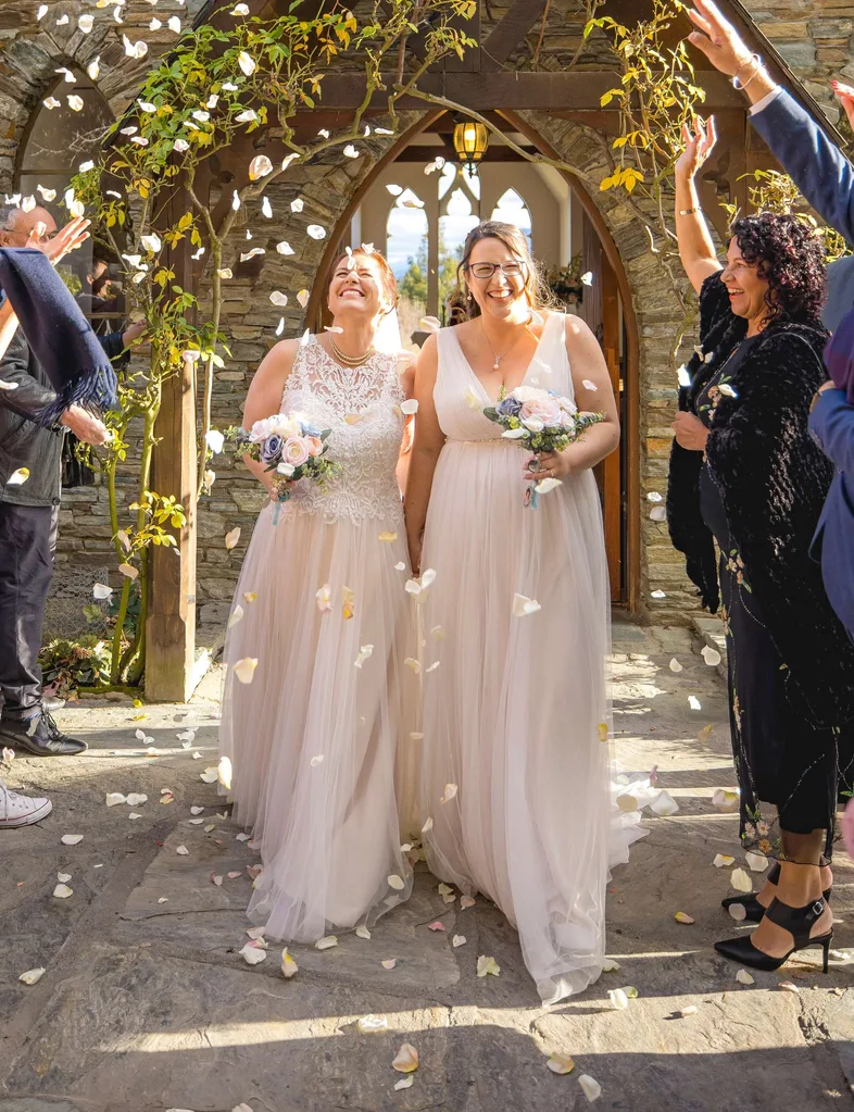 Walking out of the chapel hand in hand while being showered in flower petals