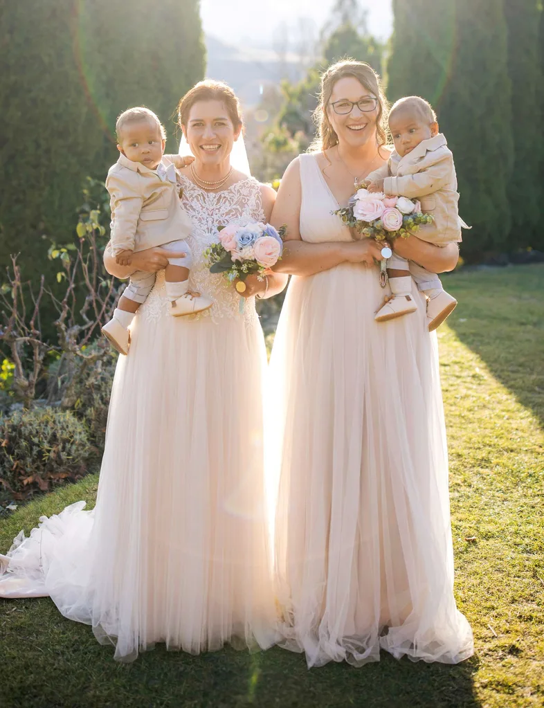 Melanie and Leah holding sons Alfie and Charlie on their wedding day