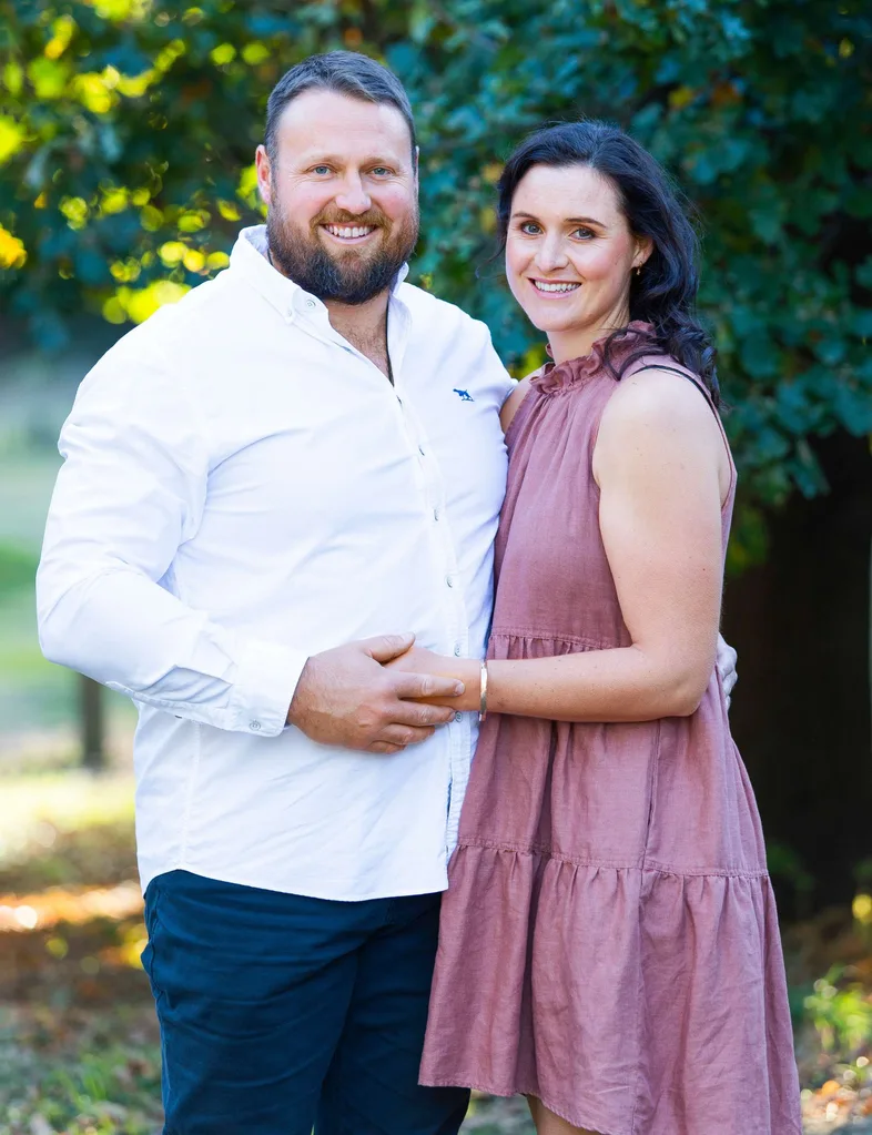 Tom and Dana standing together holding hands