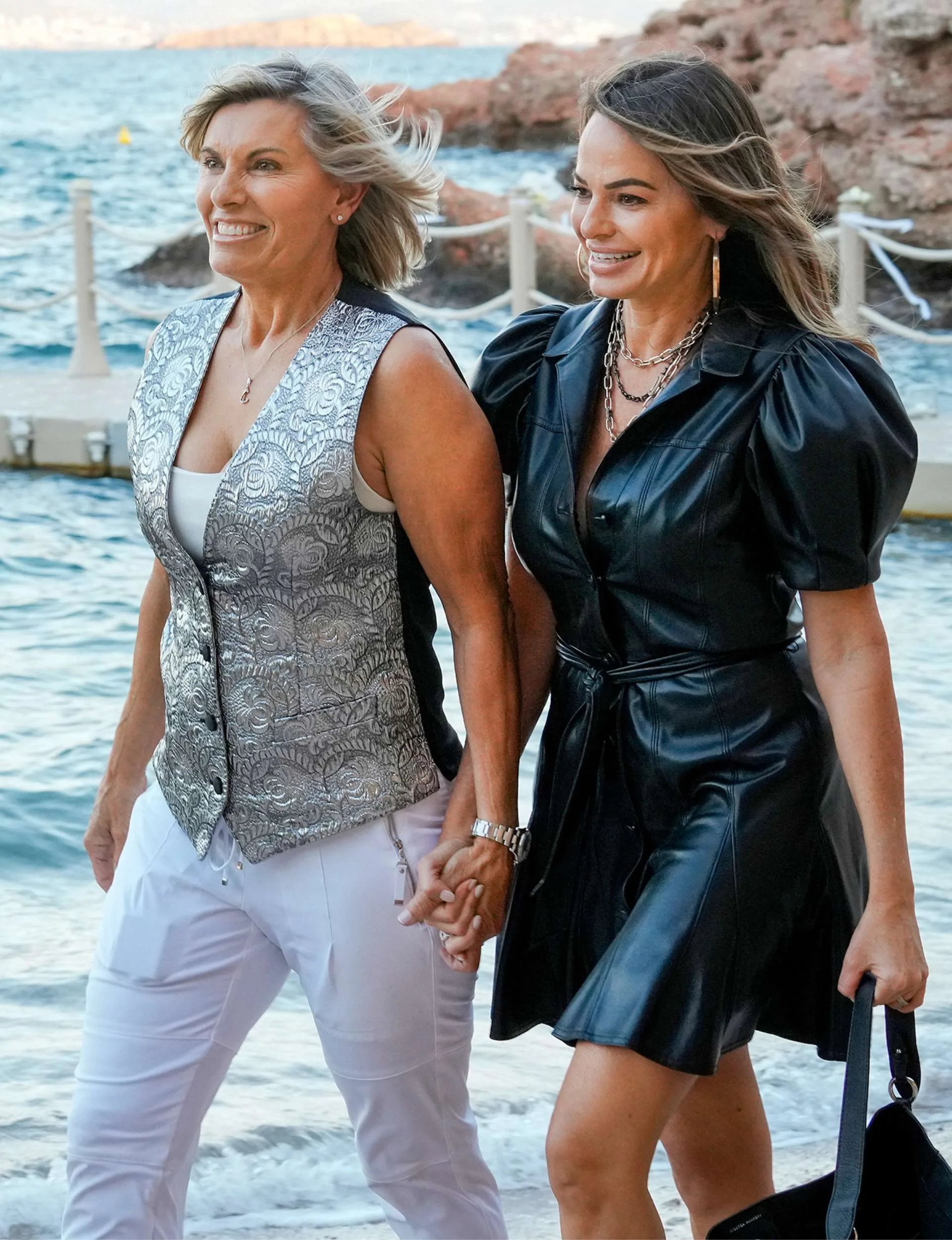 Sandy and Leah walking hand in hand up the beach after the proposal