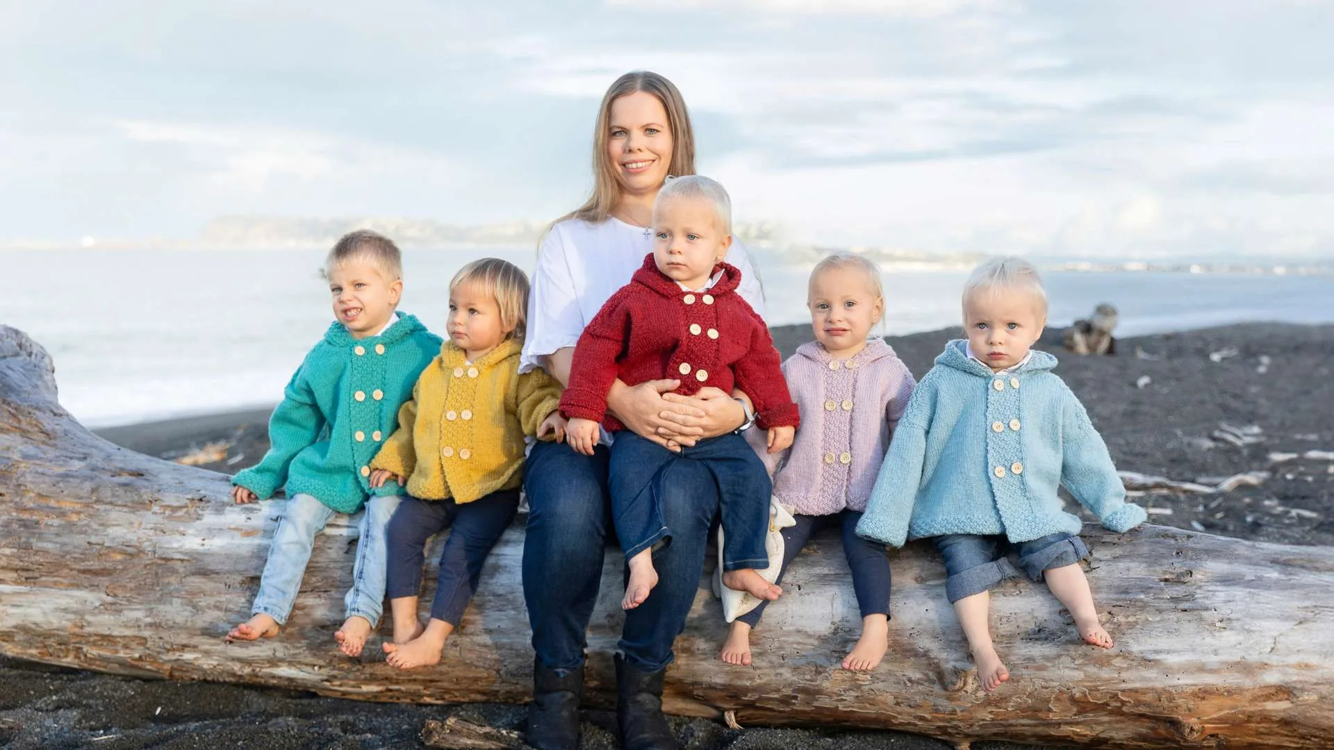Joanne with her five children sitting on a log beside her