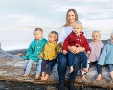 Joanne with her five children sitting on a log beside her