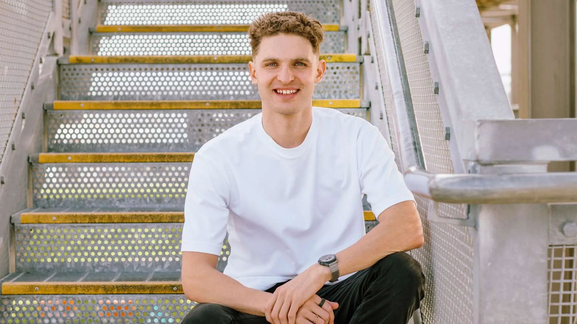 Lewis sitting on some metal stairs