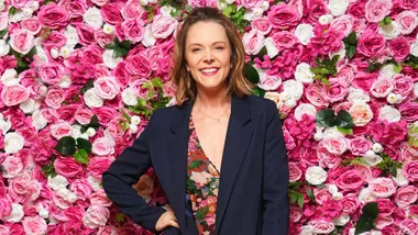 Ria standing front of a flowery background