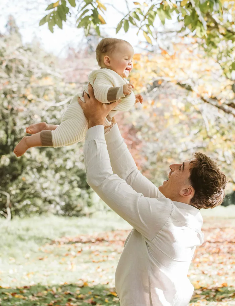 Josh Jacomb holding baby Jorgi in the air