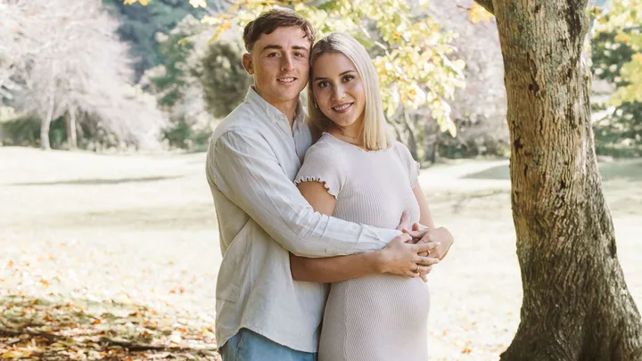 Josh Jacomb standing behind partner Bonnie, with his arms around her