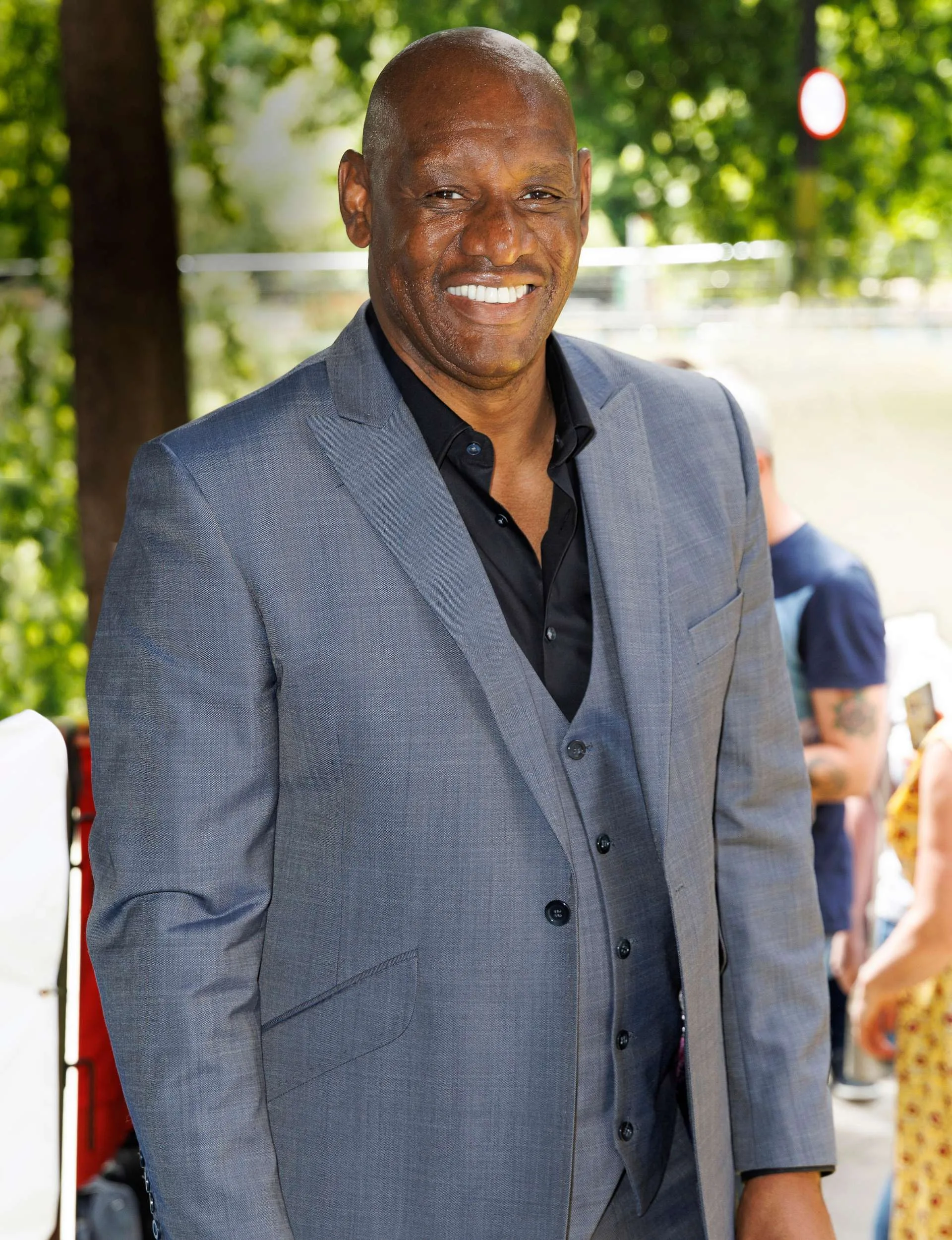 Shaun Wallace in a grey suit standing outside