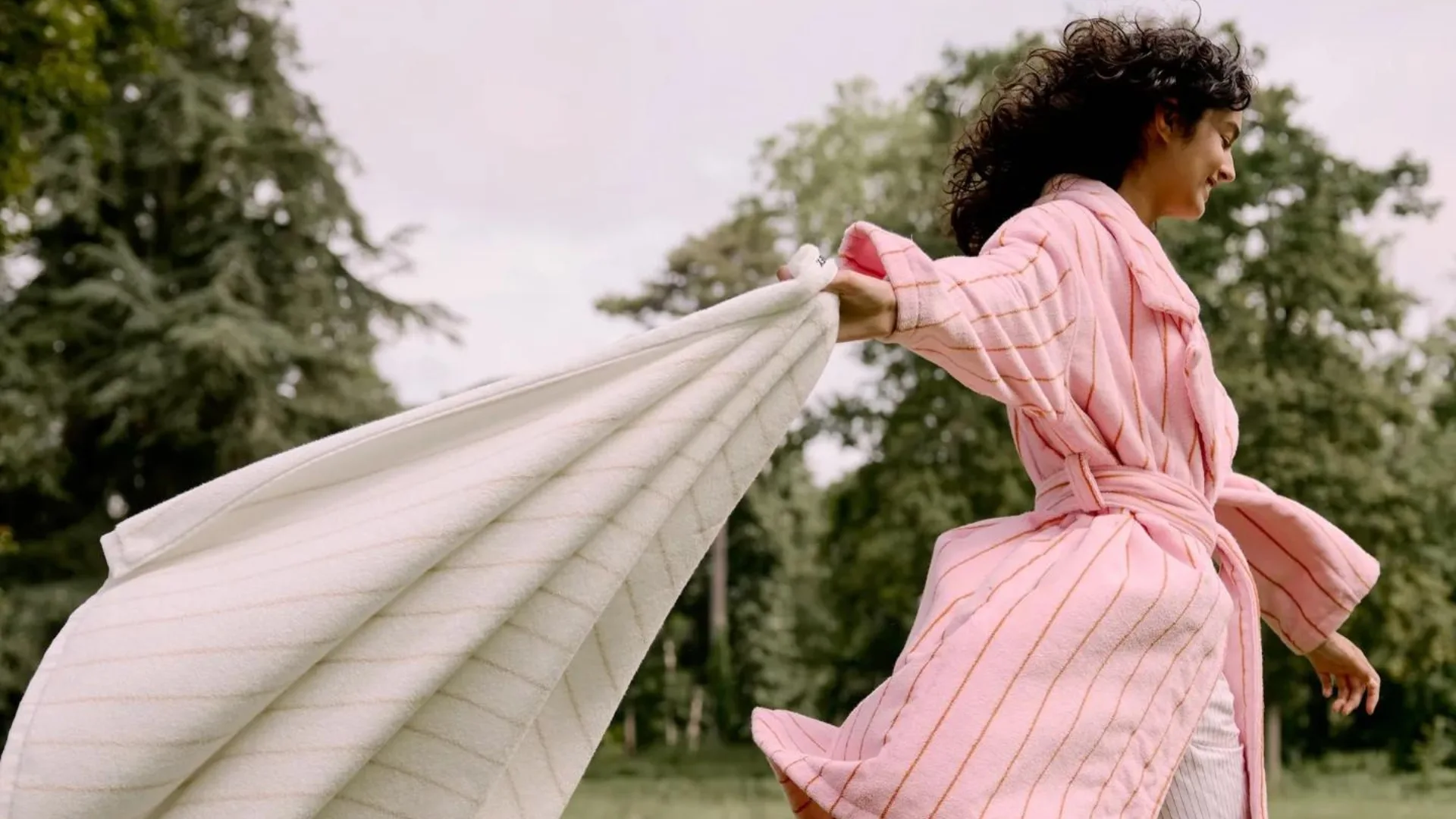 A woman in a Hommey pinstriped robe holding a towel