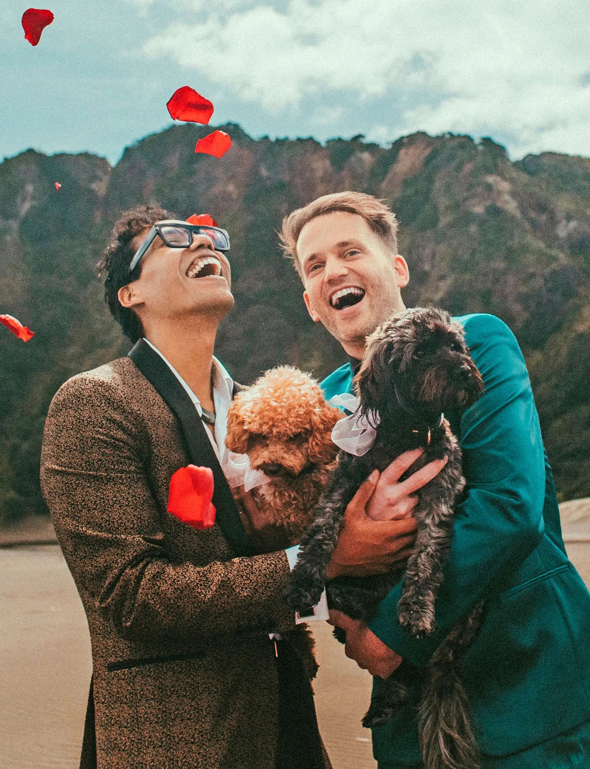 Andrew and Esaú holding puppies on their wedding day