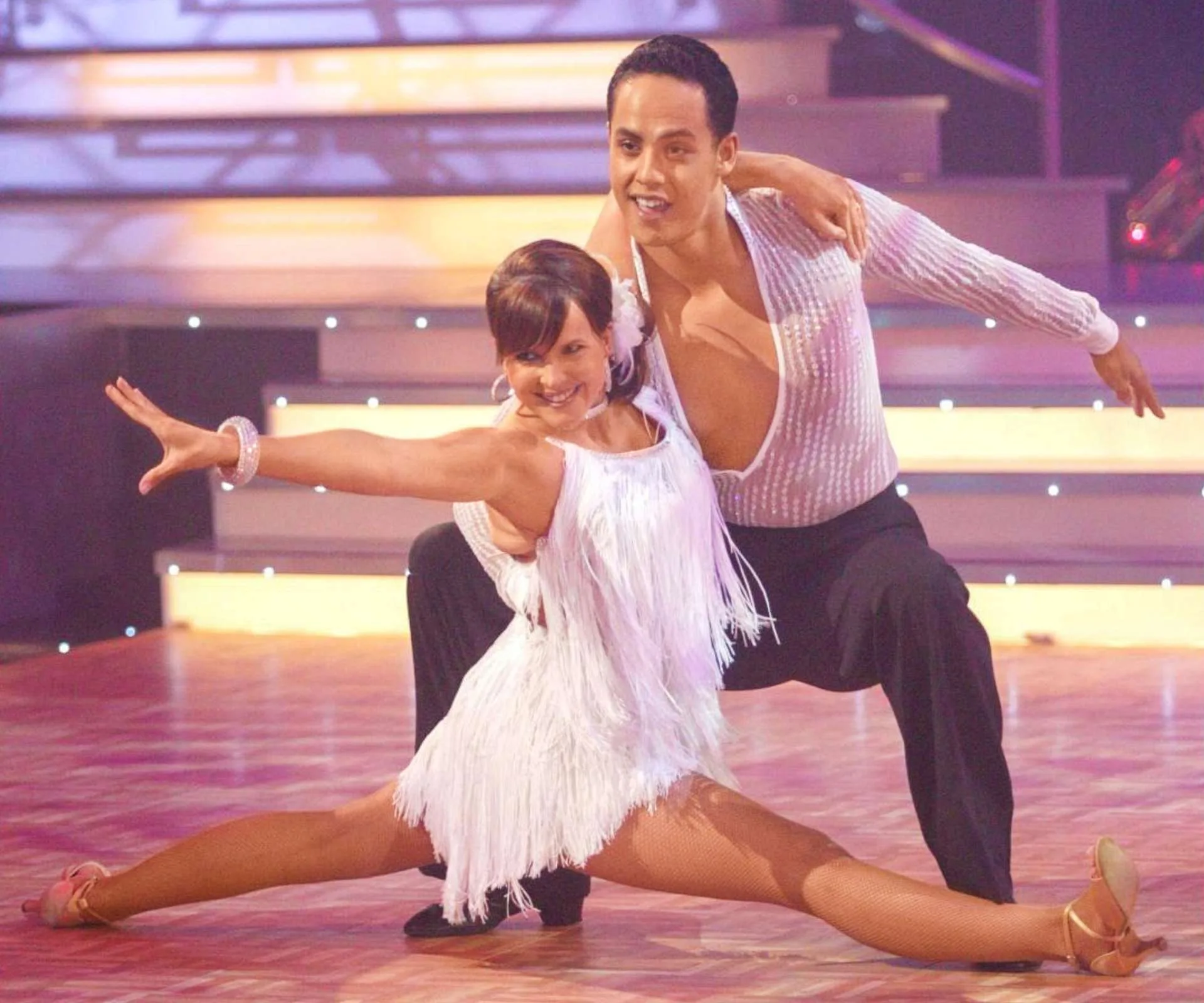 Angela on stage of Dancing With the Stars, striking a pose with Jonny Williams