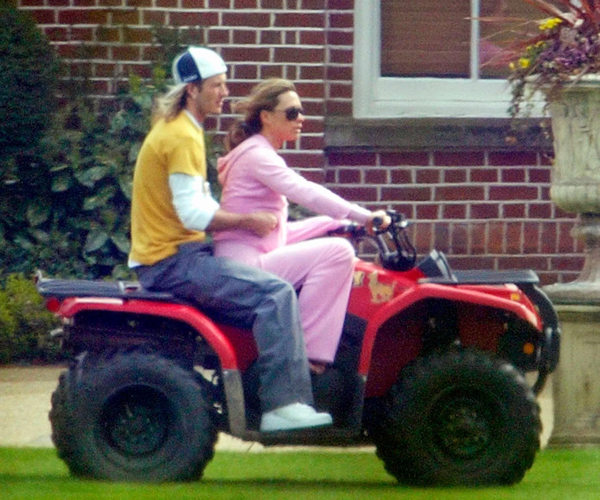 Victoria driving a quad bike with David Beckham on the back