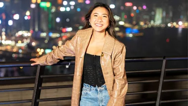 MasterChef star Mimi in front of a blurred city at night