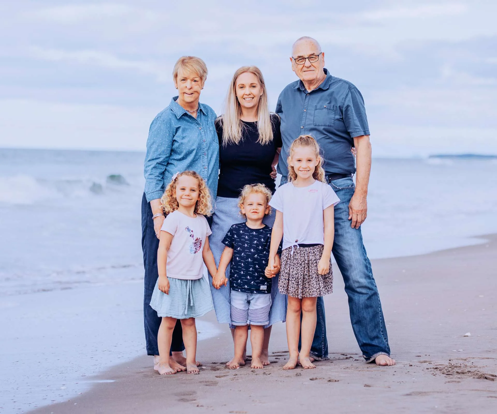 Celia Farnworth with her family standing on the shore of a beach