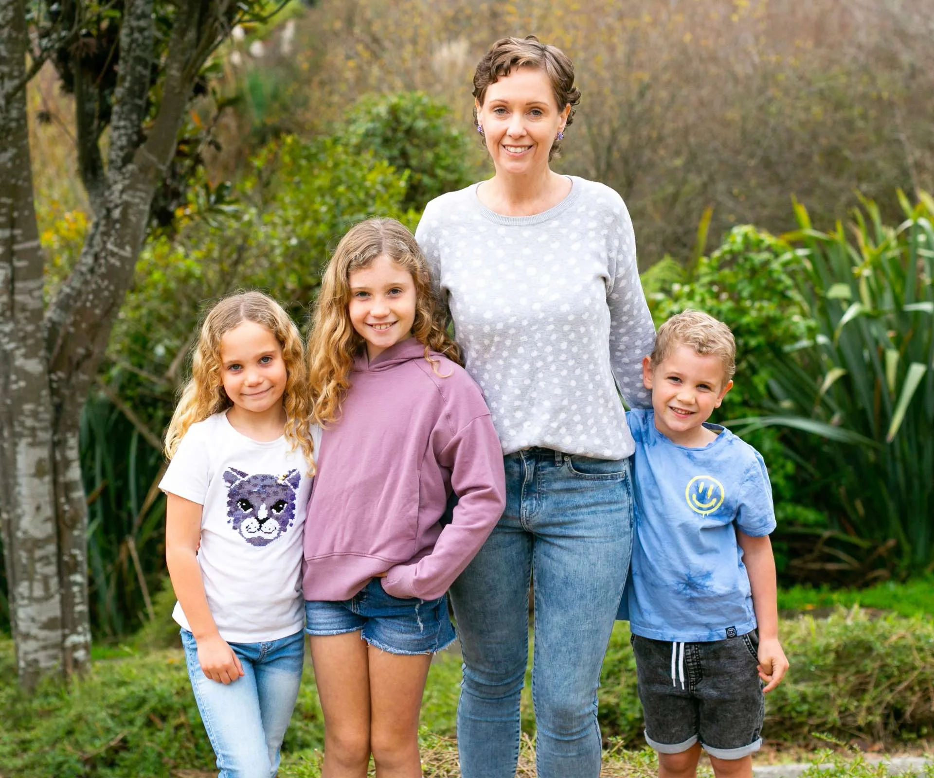 Celia standing in the garden with her three kids
