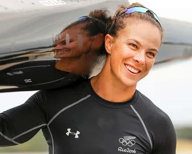 Olympian Dame Lisa Carrington with her kayak over her shoulder