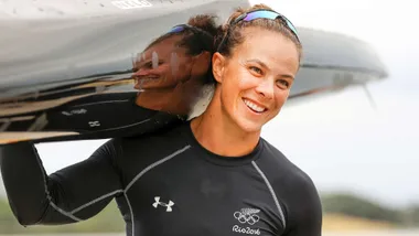 Olympian Dame Lisa Carrington with her kayak over her shoulder