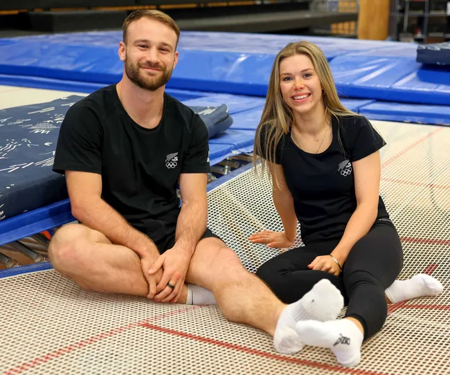 2024 Olympians Dylan Schmidt and Maddie Davidson sitting on a trampoline